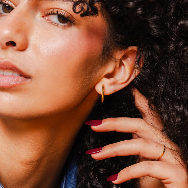 model wearing 14k solid gold hoop earring and ring