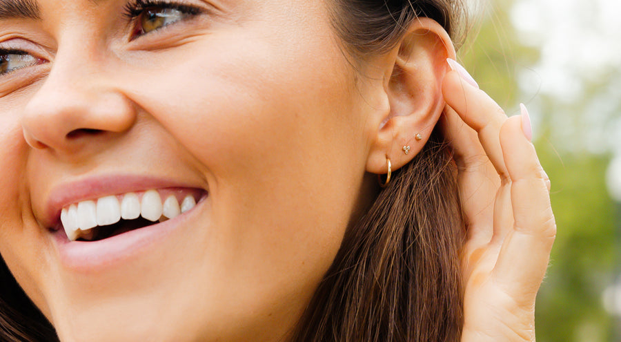 model wearing gold live in hoop, cz trinity and cz bezel live in stud earrings