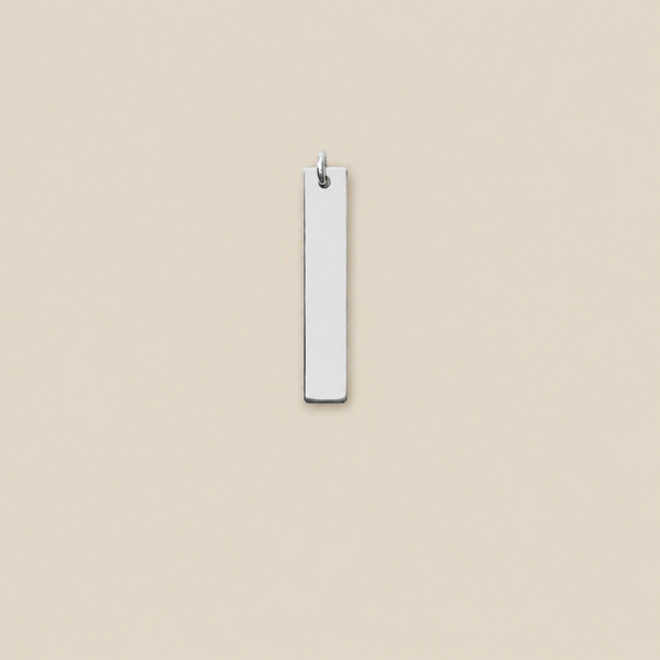 A minimalist, vertically oriented rectangular silver bar pendant with a small metal loop at the top, shown against a solid beige background.