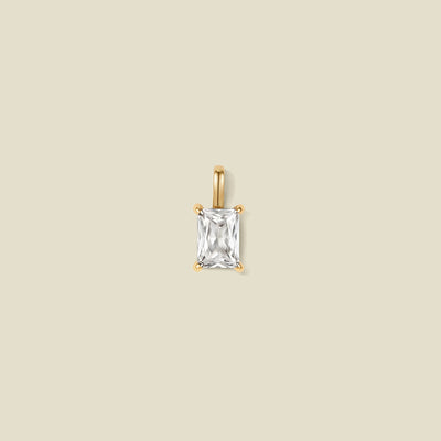 A pendant charm featuring a clear baguette-cut prong set gemstone.