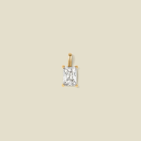 A pendant charm featuring a clear baguette-cut prong set gemstone.