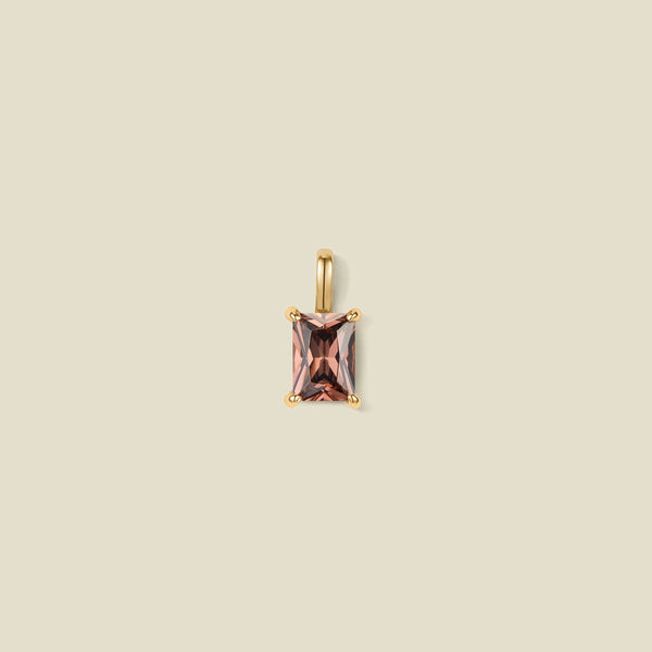 A pendant charm featuring a black/brown baguette-cut prong set gemstone.
