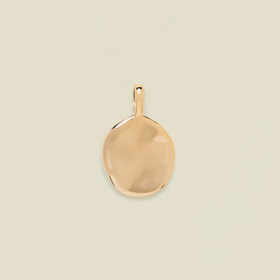 Gold pendant on a beige background