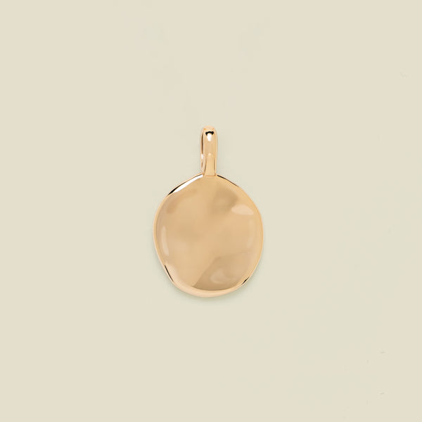 Gold pendant on a beige background