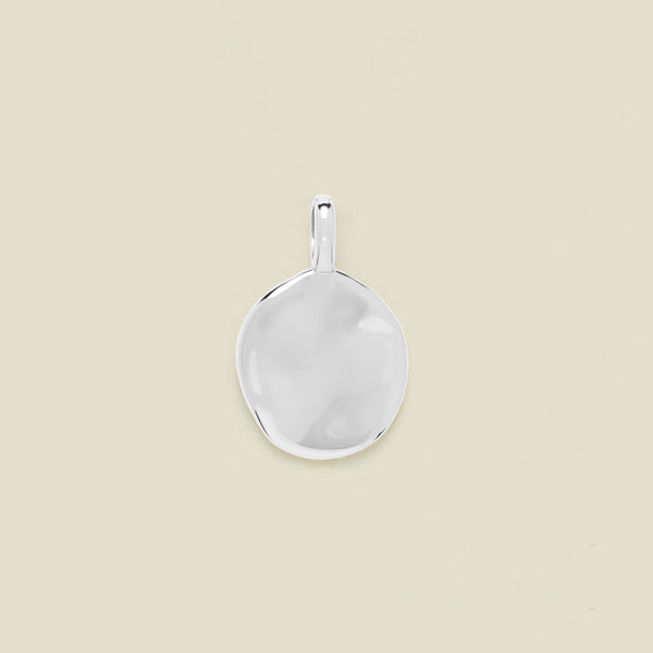 Silver pendant on a beige background