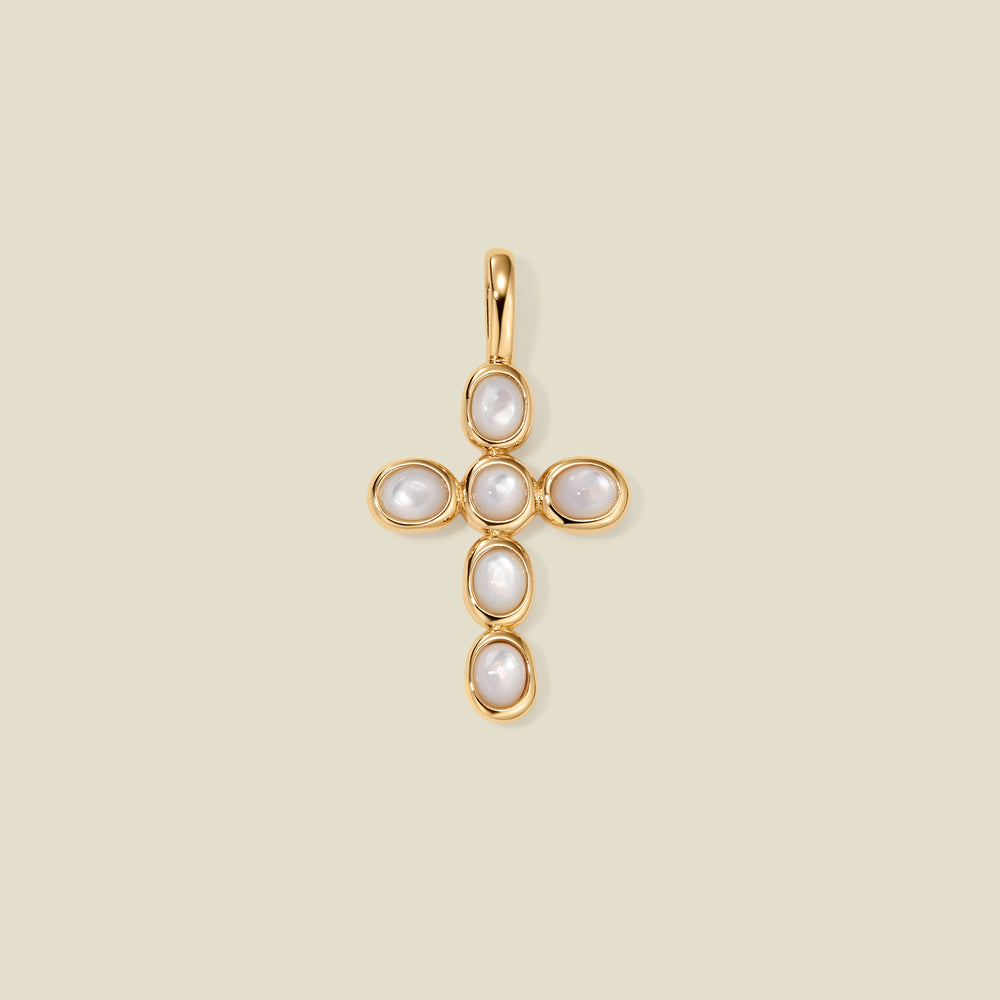 Gold cross pendant made of bezel-set pearl stones, suspended against a neutral background.