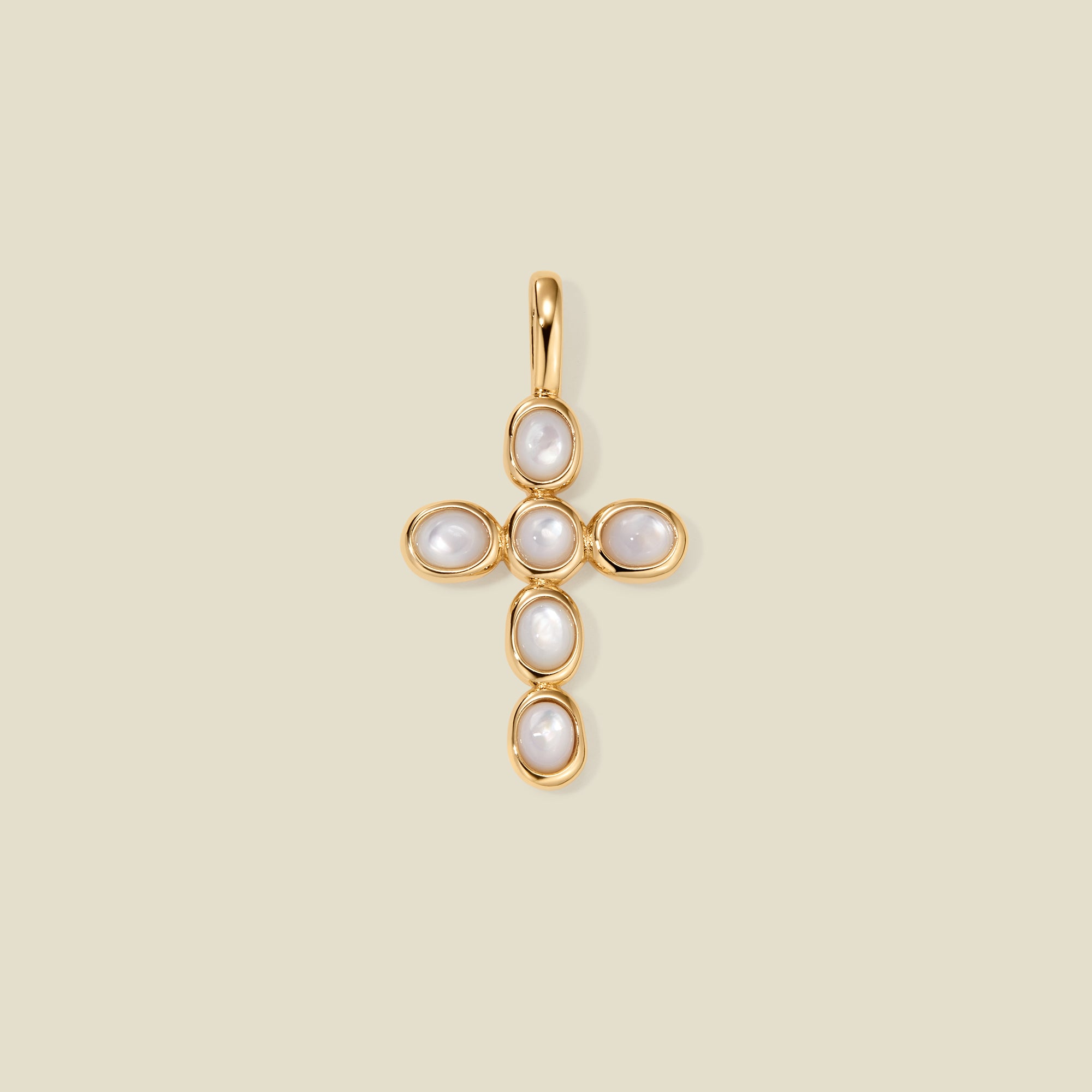 Gold cross pendant made of bezel-set pearl stones, suspended against a neutral background.