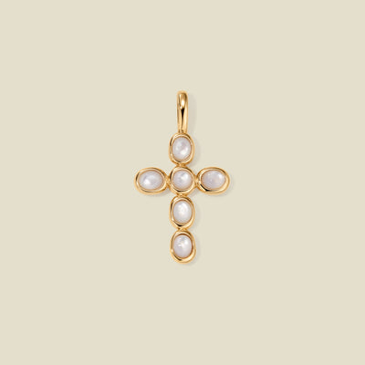 Gold cross pendant made of bezel-set pearl stones, suspended against a neutral background.