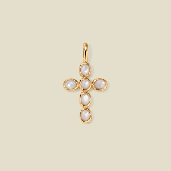 Gold cross pendant made of bezel-set pearl stones, suspended against a neutral background.