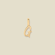 A polished gold initial pendant charm shaped like the letter 'G' in a cursive script, centered on a solid light beige background.
