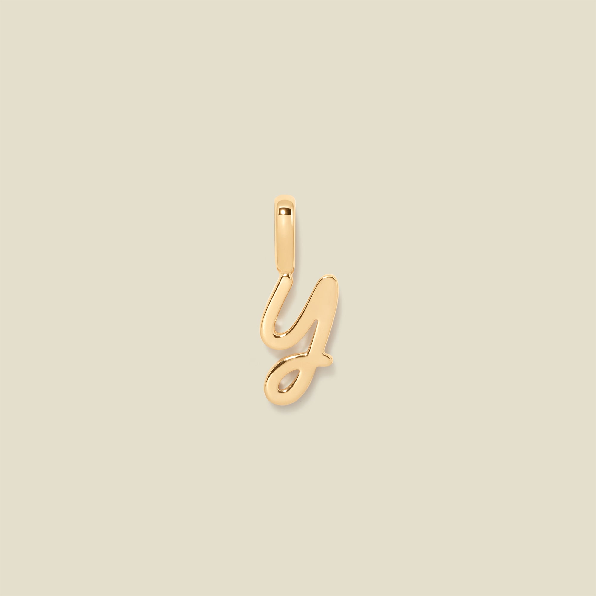 A gold charm letter Y against a neutral background.