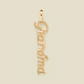 Gold 'Grandma' charm on a beige background