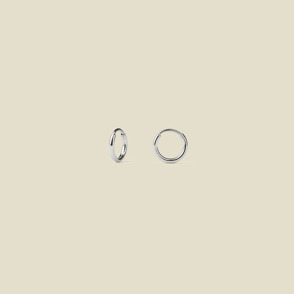 Silver hoops against a neutral background.