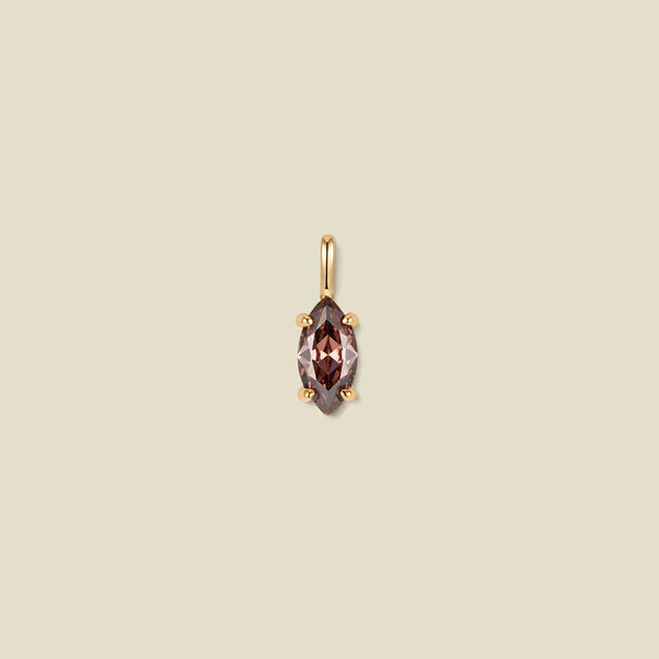 A small gold pendant featuring a marquise-cut faceted brown/black  gemstone in a four-prong setting, centered on a solid beige background.