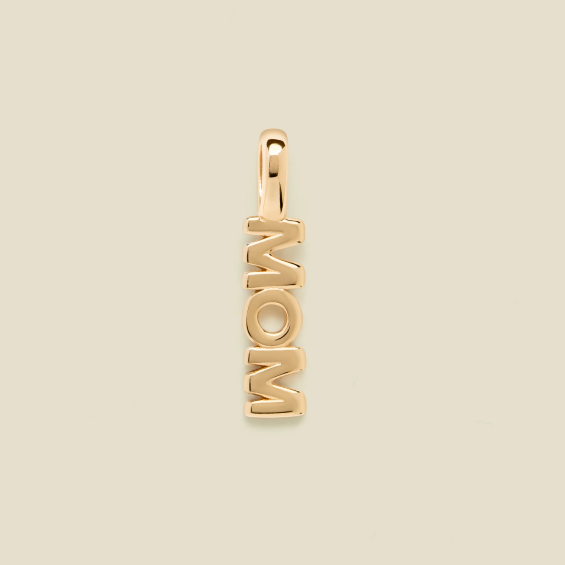 Gold "MOM" charm on a beige background