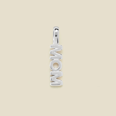 Silver 'MOM' pendant on a beige background