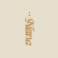 Gold "Nana" charm on a beige background