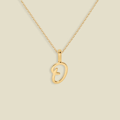 A gold initial pendant necklace featuring a script uppercase letter 'O' , suspended from a delicate gold chain against a solid light beige background.