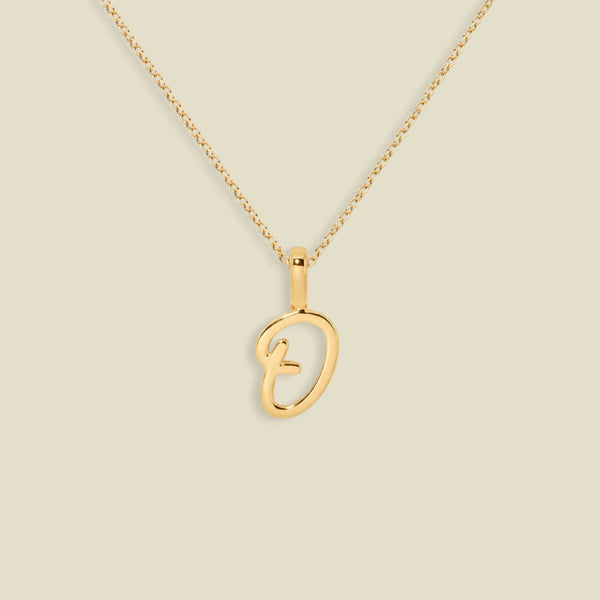 A gold initial pendant necklace featuring a script uppercase letter 'O' , suspended from a delicate gold chain against a solid light beige background.