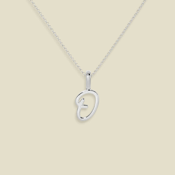 A silver initial pendant necklace featuring a script uppercase letter 'O' , suspended from a delicate silver chain against a solid light beige background.