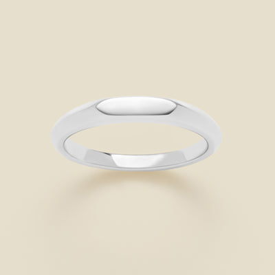 Silver signet ring on a beige background