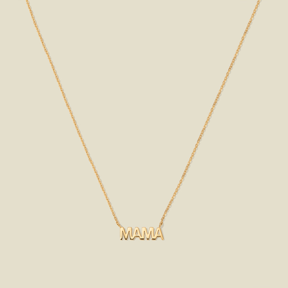 Gold “MAMA” letter necklace with delicate chain on a beige background