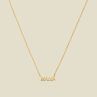 Gold “MAMA” letter necklace with delicate chain on a beige background
