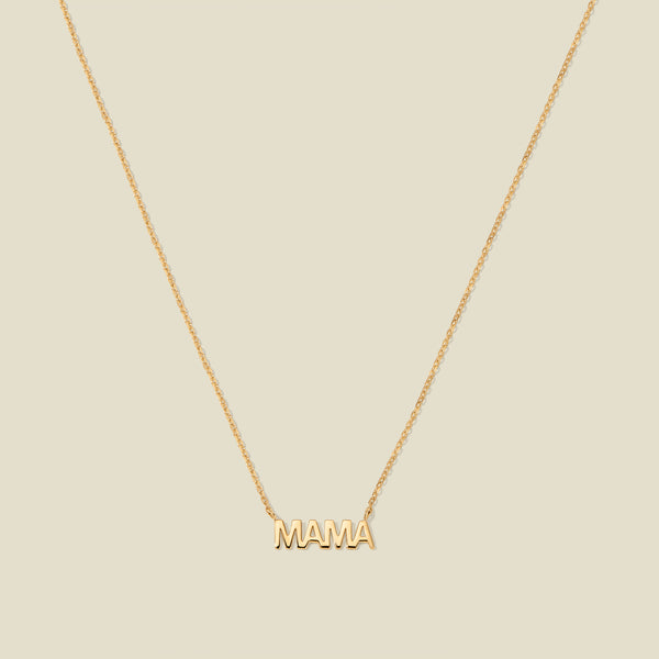 Gold “MAMA” letter necklace with delicate chain on a beige background