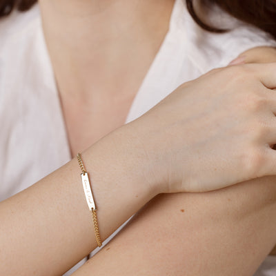 Gold bracelet engraved with a name on a person's wrist 