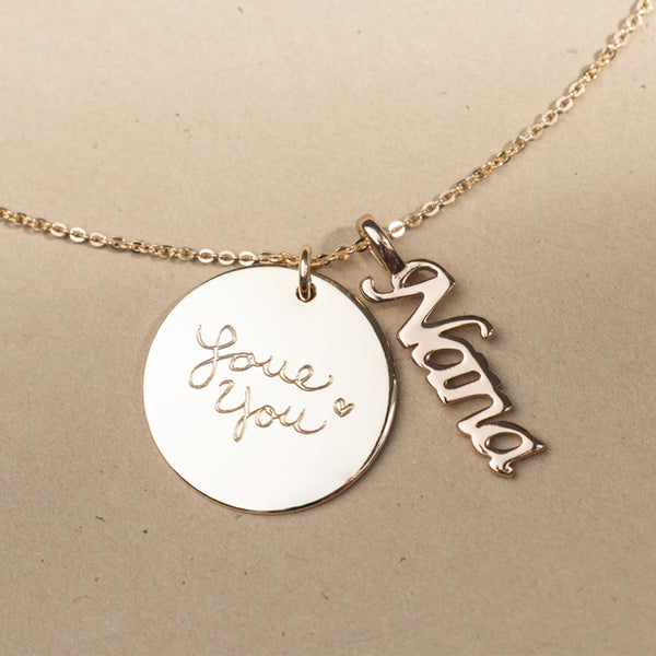 Gold necklace with 'Love You' and 'Nana' charms on a beige background